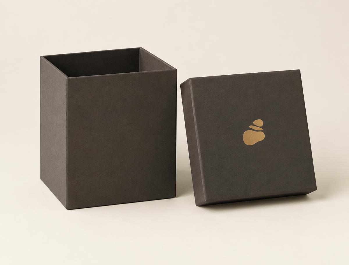 Tall square rigid two-piece candle box in charcoal wrap with a gold foil stamp