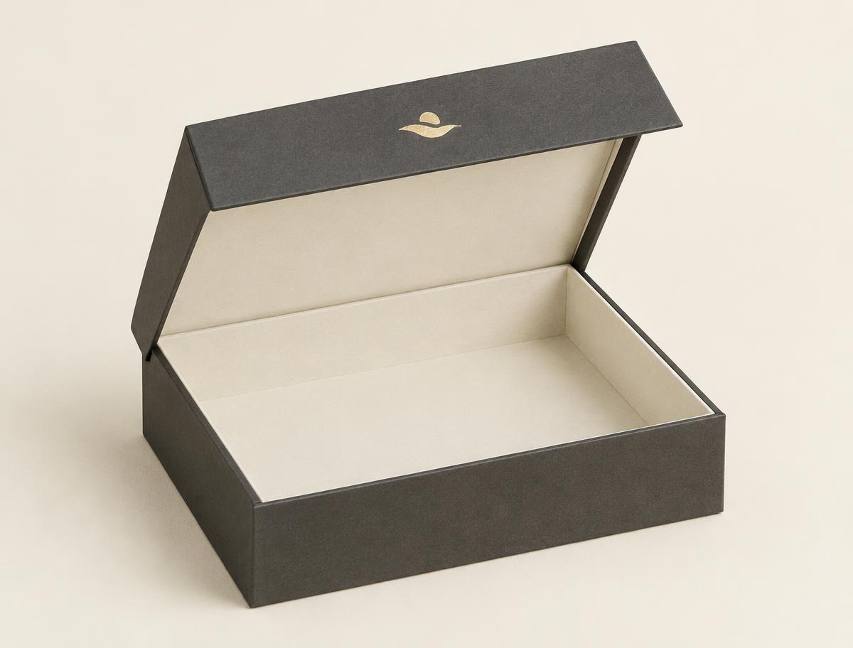Deep landscape rigid clamshell box with the hinged lid open, ivory-lined interior