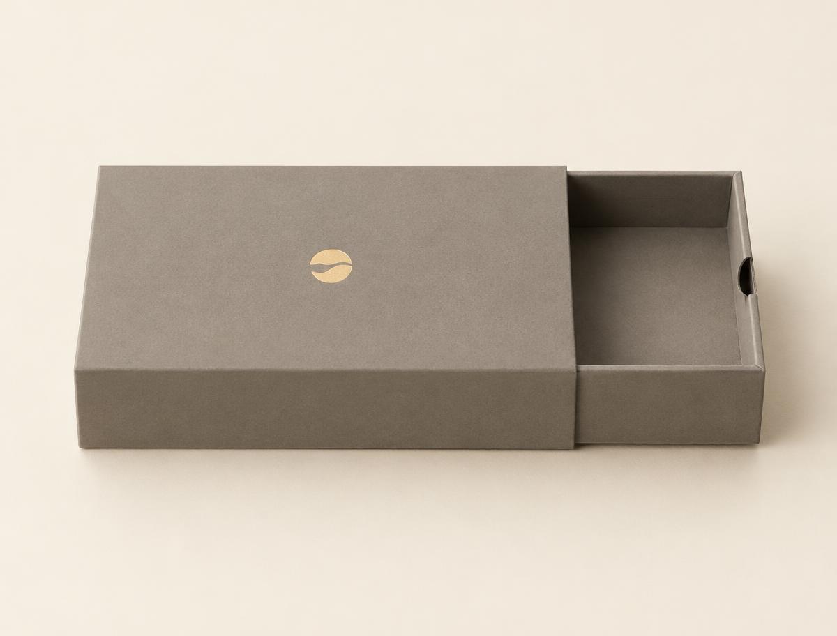 Medium rigid drawer box with the inner tray partly slid out, gold foil stamp on the sleeve